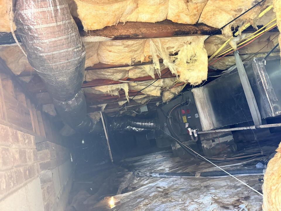 Crawlspace inspection showing insulation framing and moisture conditions